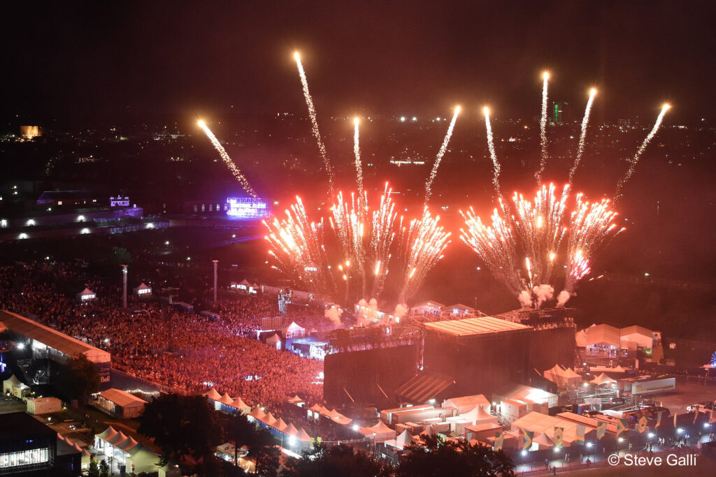 Fireworks rise above the Festival d’été de Québec grounds at night