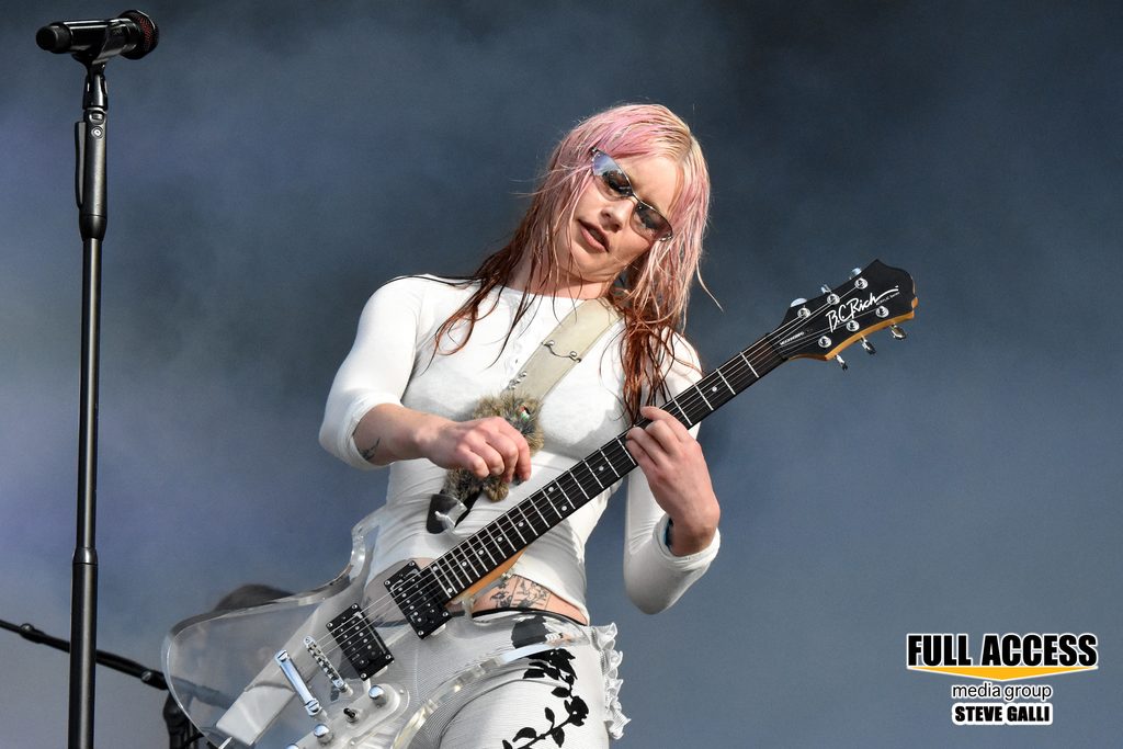 Pink-haired guitarist playing an electric guitar at Bonnaroo