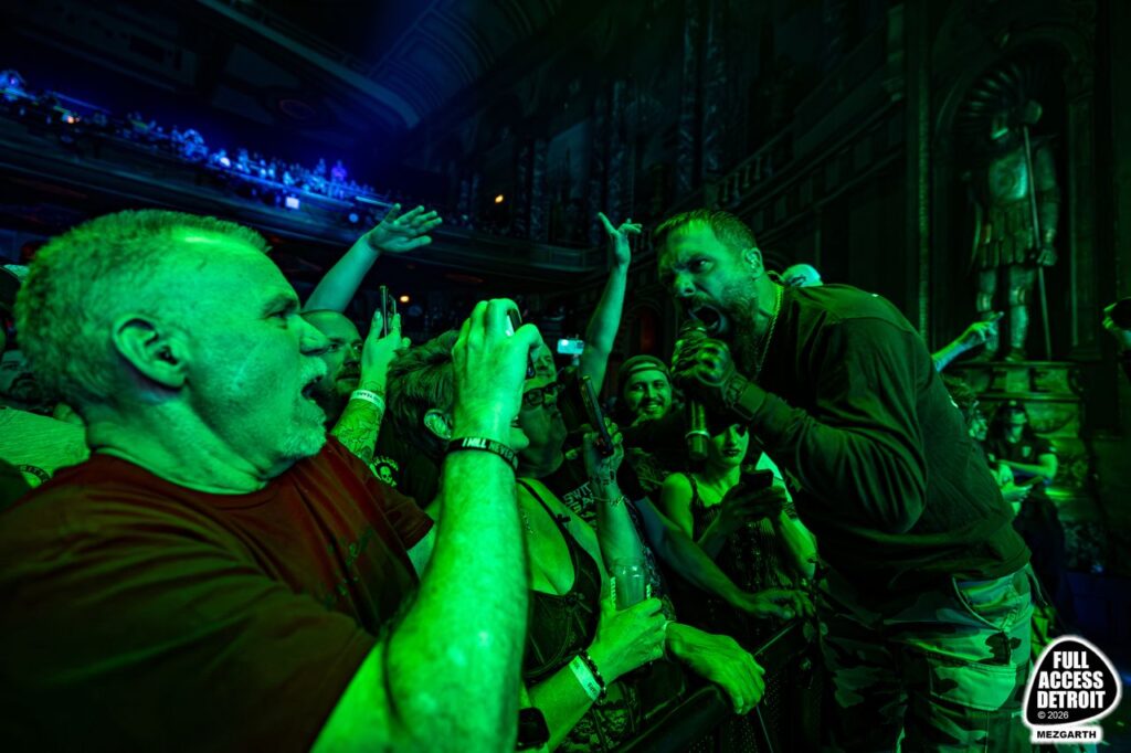 Vocalist leaning toward fans at the Fillmore crowd barrier