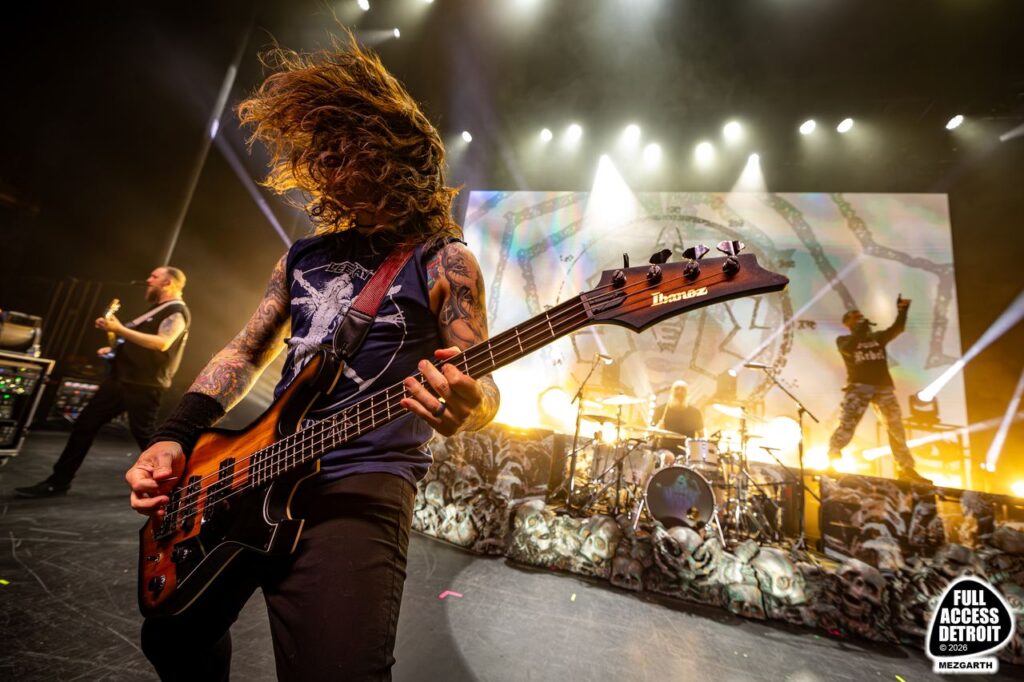 Bassist headbanging during a brightly lit metal performance