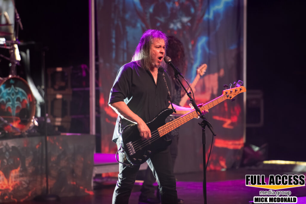 Bassist performing under purple stage lights