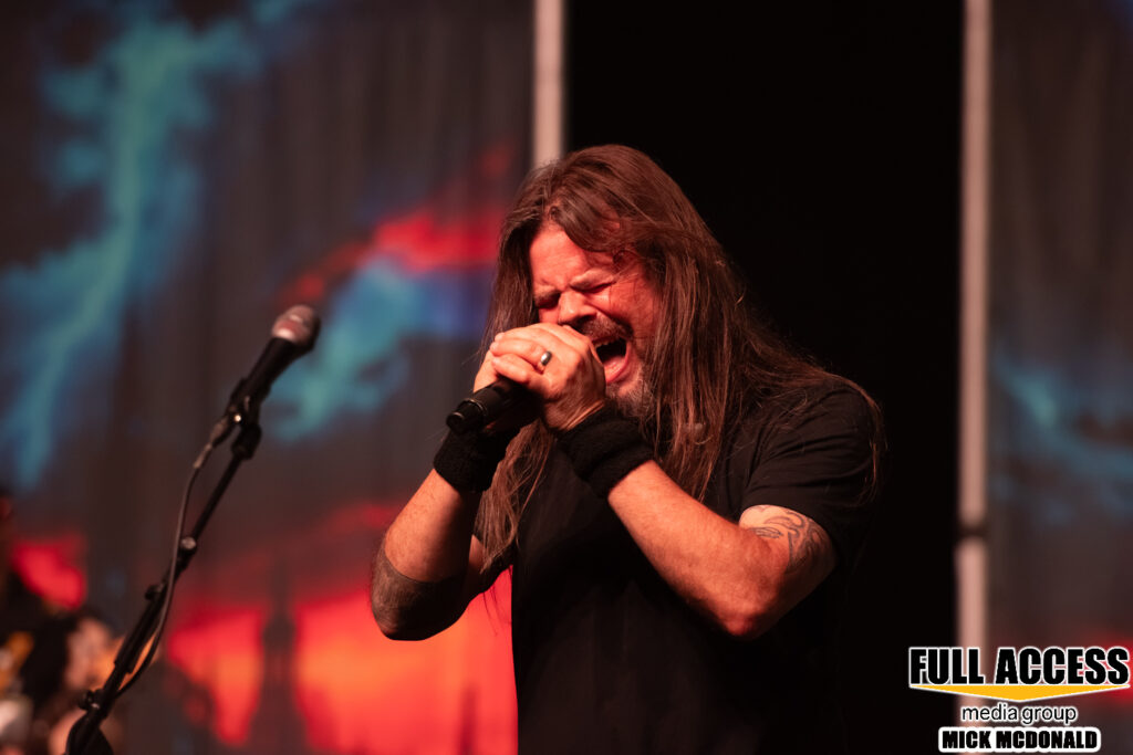 Vocalist gripping a microphone with both hands during a rock performance
