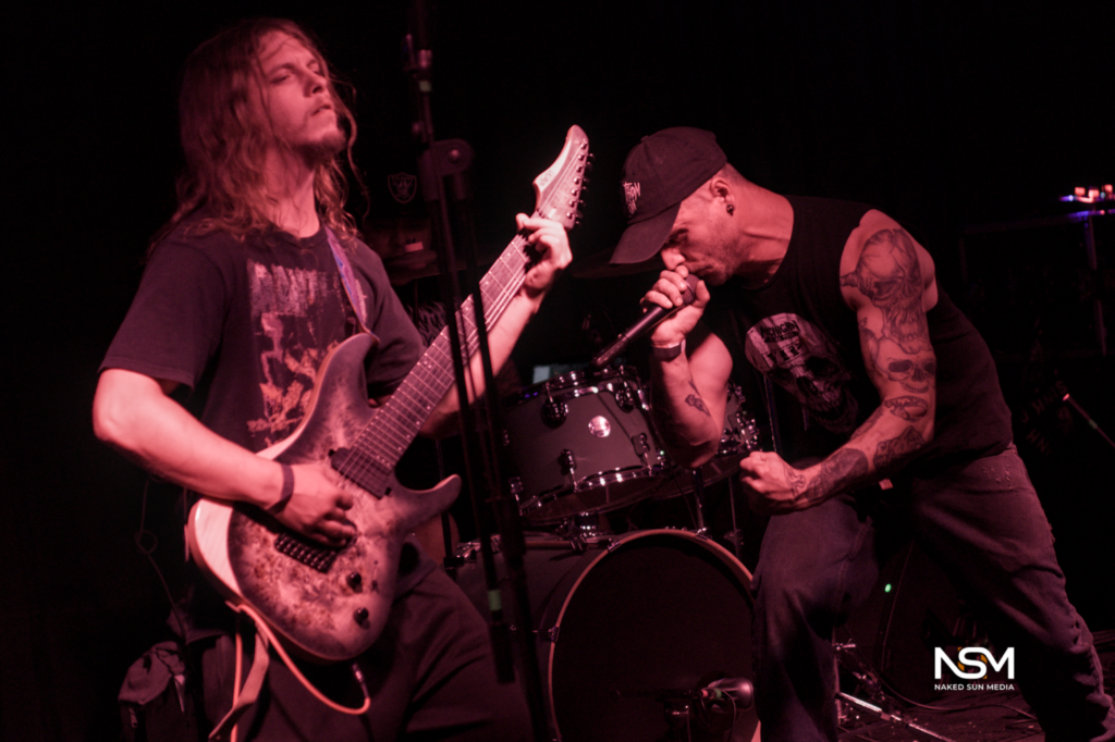 Long-haired guitarist beside a vocalist at The Sanctuary