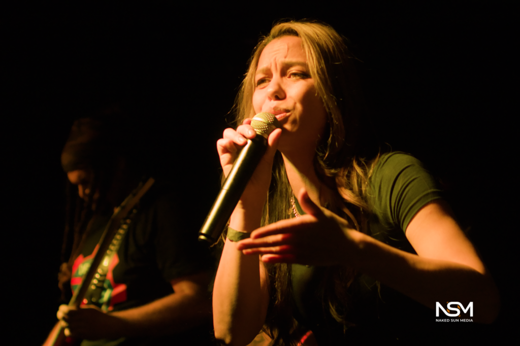 Vocalist singing and gesturing toward the crowd