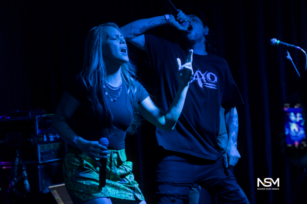 Two vocalists sharing the stage during a metalcore performance